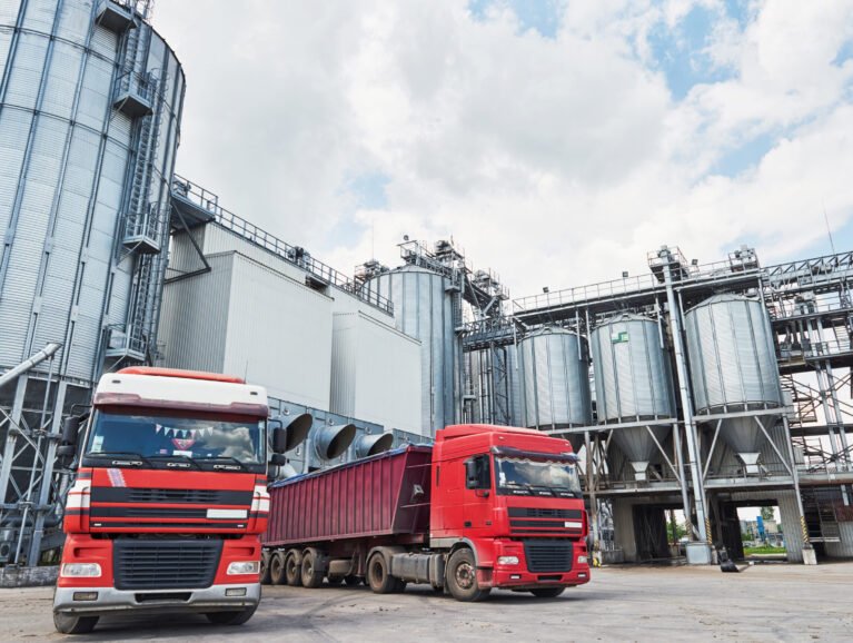 Agricultural Silo - Building Exterior, Storage and drying of grains, wheat, corn, soy, sunflower and two trucks waiting